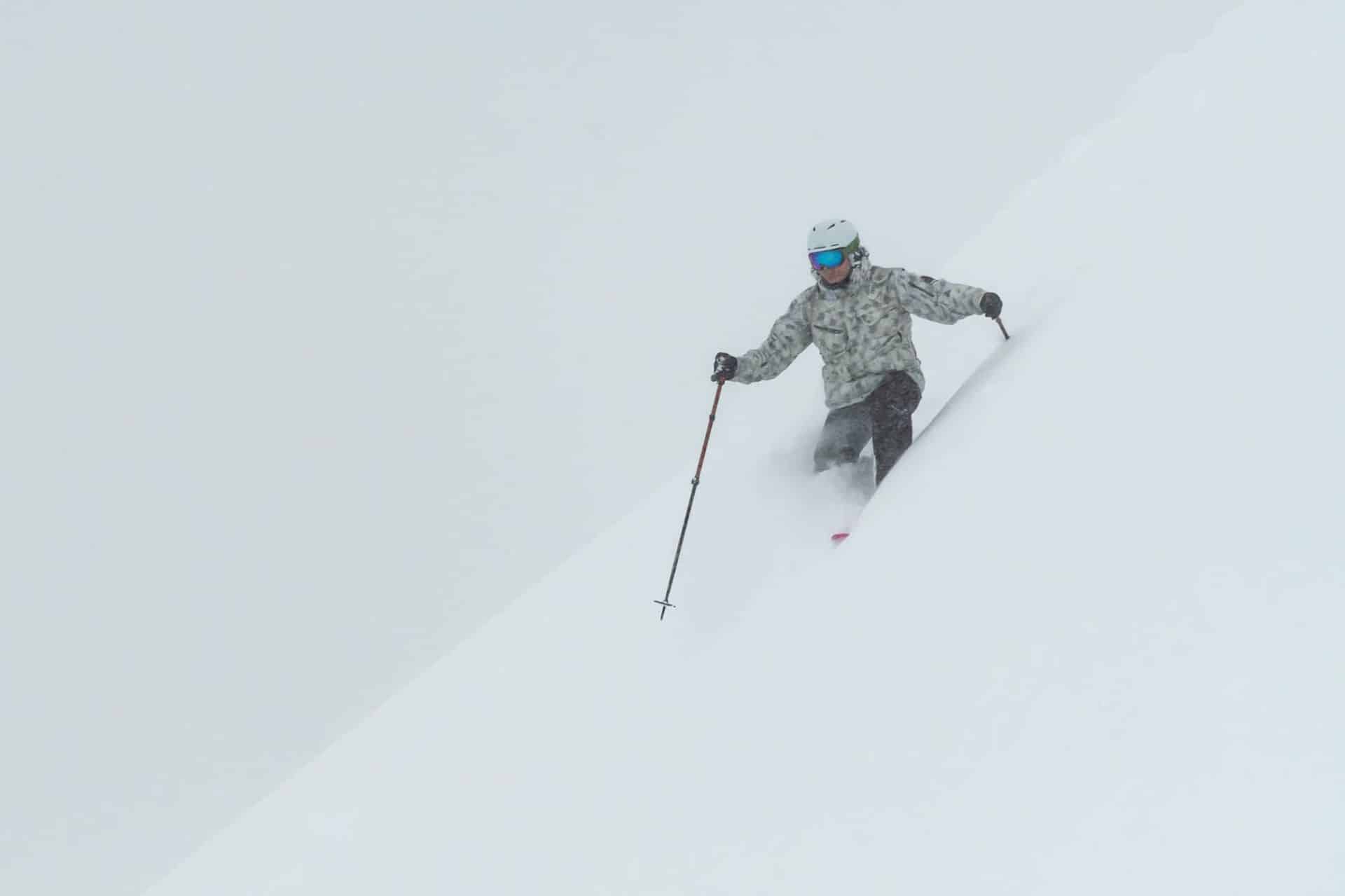 Back of backcountry skier looking over snowy mountain peak