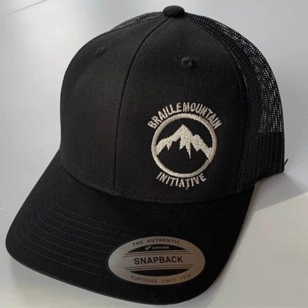 Front view of snapback trucker hat, black color, with Braille Mountain Initiative logo stitched