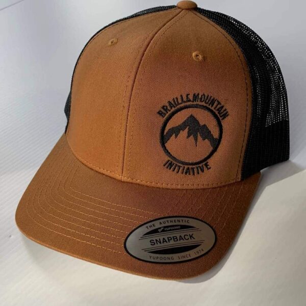 Front view of snapback trucker hat, caramel color, with Braille Mountain Initiative logo stitched