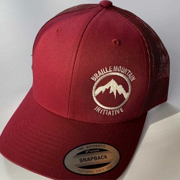 Front view of snapback trucker hat, red color, with Braille Mountain Initiative logo stitched