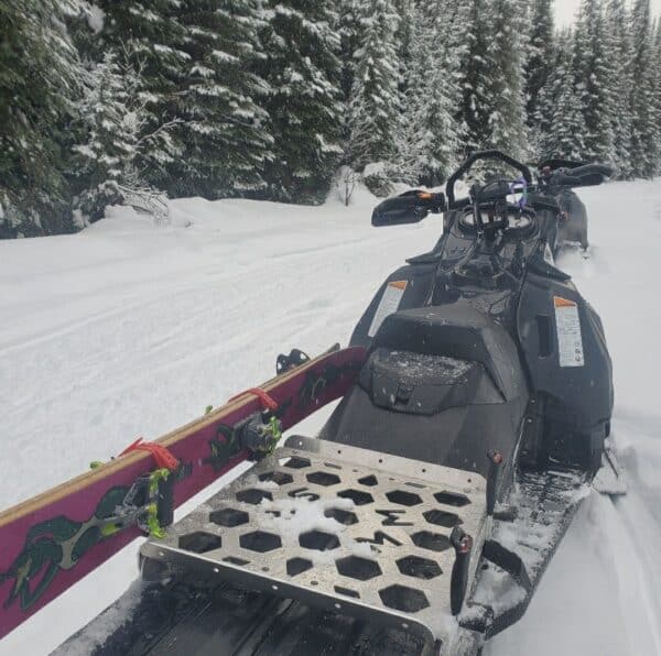 Back end of a snowmobile with a Mad Max Sled Rack carring a single pair of skis on the left side.