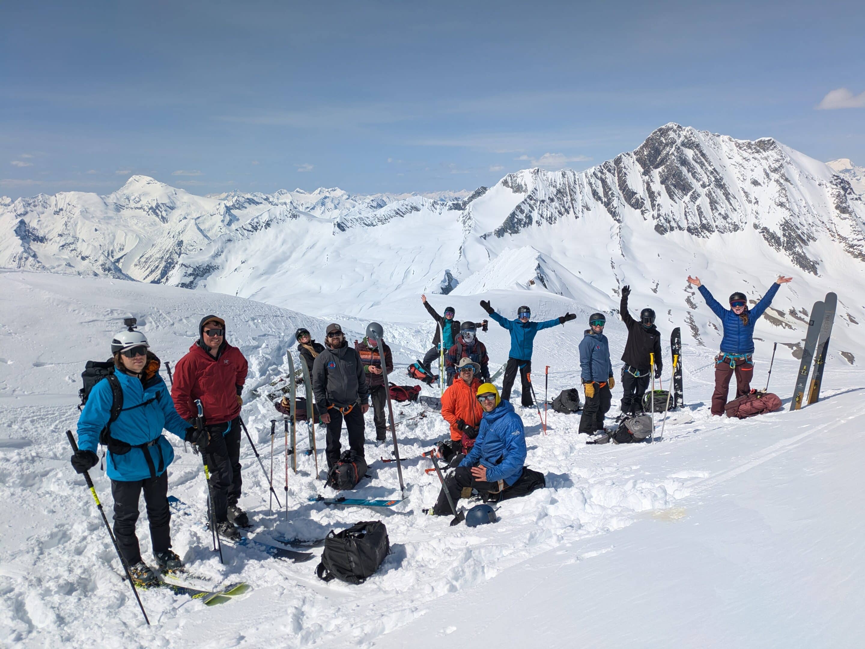 Large group shot of 13 people at the summit of Nordic Glacier, mid-way through transitioning, snacking, and hydrating.