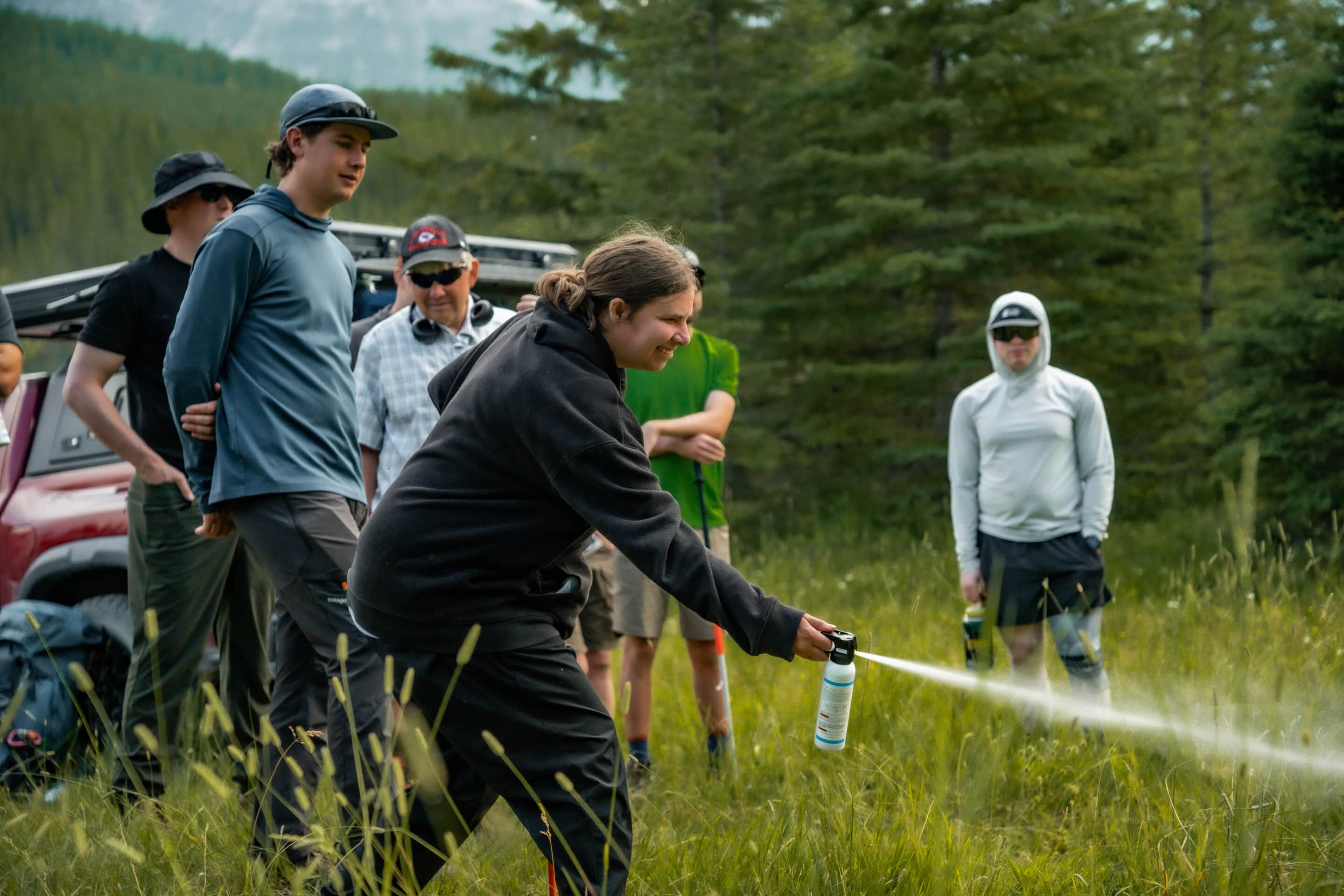 A blind woman practices deploying innert bear spray during a educational session on bear awareness and safety.